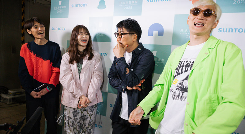 インタビュー形式のトークをするたなしん亀田誠治の背景に協賛企業のロゴが掲出されている。